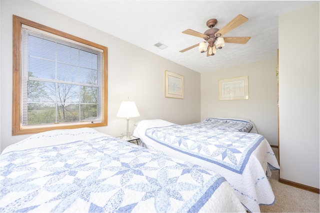 carpeted bedroom with ceiling fan, visible vents, and baseboards