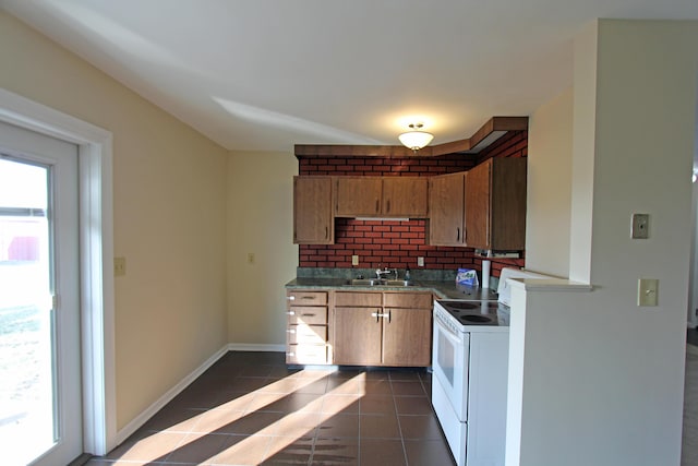 kitchen featuring tasteful backsplash, sink, dark tile patterned flooring, and white range with electric cooktop