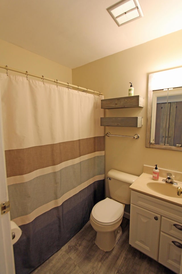 bathroom featuring wood-type flooring, vanity, and toilet