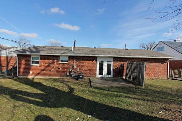 rear view of property featuring french doors, a yard, central AC unit, and a patio