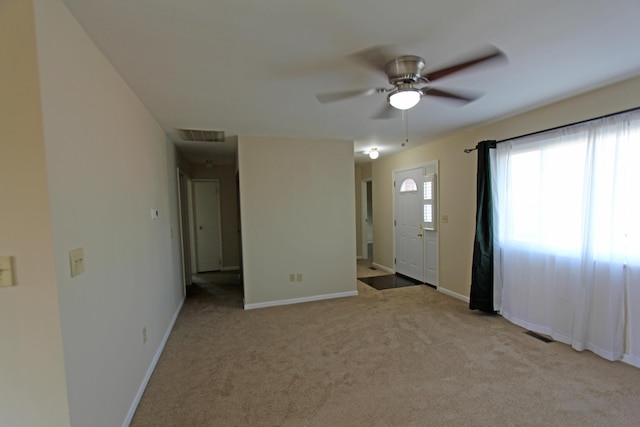 spare room with light colored carpet and ceiling fan