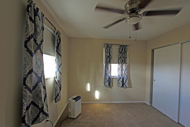 unfurnished bedroom with light carpet, a closet, and ceiling fan