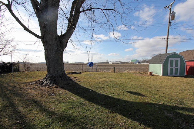 view of yard with a storage shed and a rural view