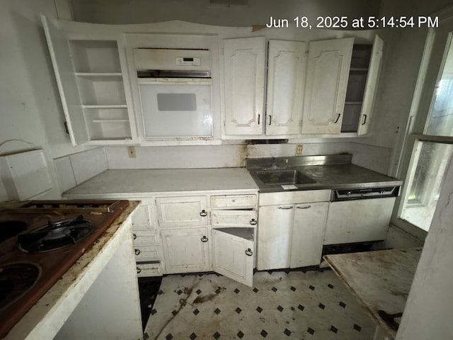 542 N Main St, Ada, OH 45810 - kitchen featuring white oven, white cabinetry, light floors, dishwashing machine, and light countertops