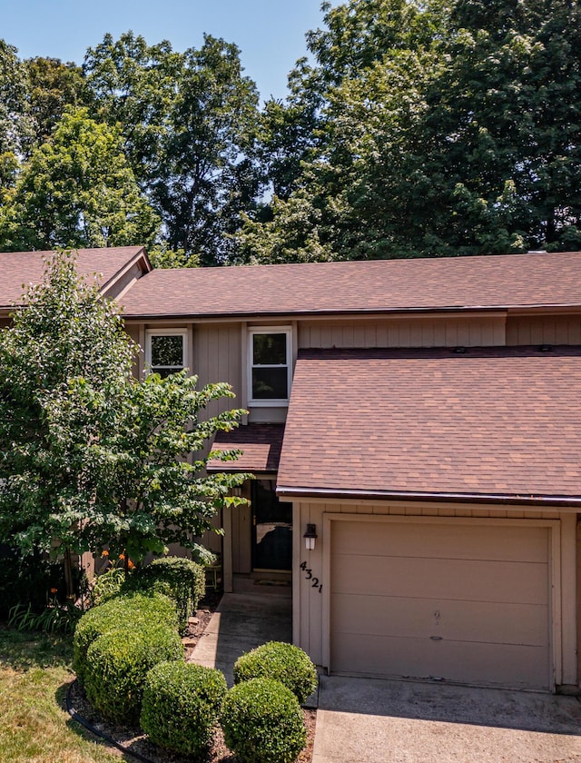 4321 Frontenac Dr, Beavercreek, OH 45440 - view of front facade with board and batten siding, roof with shingles, driveway, and a garage