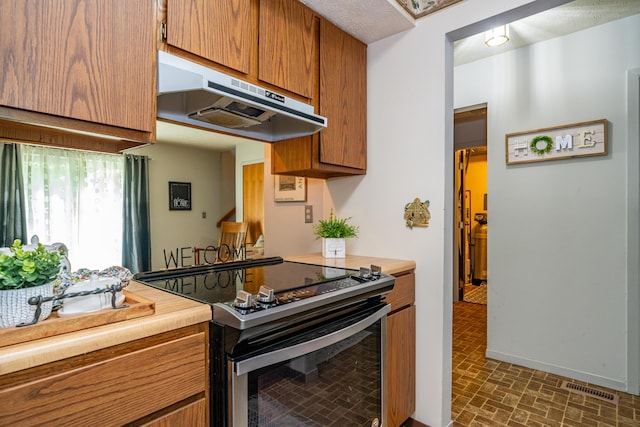 4321 Frontenac Dr, Beavercreek, OH 45440 - kitchen featuring electric stove, under cabinet range hood, brown cabinets, light countertops, and brick patterned floors
