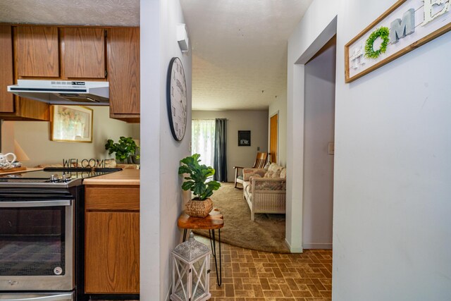 4321 Frontenac Dr, Beavercreek, OH 45440 - kitchen with stainless steel range with electric stovetop, under cabinet range hood, brick patterned flooring, brown cabinets, and light countertops