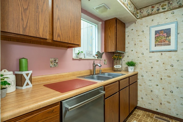 4321 Frontenac Dr, Beavercreek, OH 45440 - kitchen with stainless steel dishwasher, wallpapered walls, light countertops, brown cabinets, and brick patterned flooring