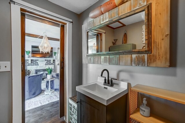 7748 Walnut St, Russells Point, OH 43348 - bathroom with a glass covered fireplace, a notable chandelier, wood finished floors, and vanity