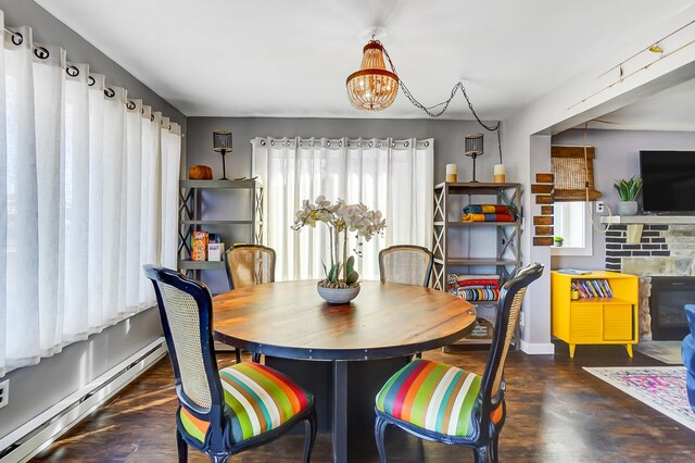 7748 Walnut St, Russells Point, OH 43348 - dining space with a chandelier, baseboard heating, and wood finished floors