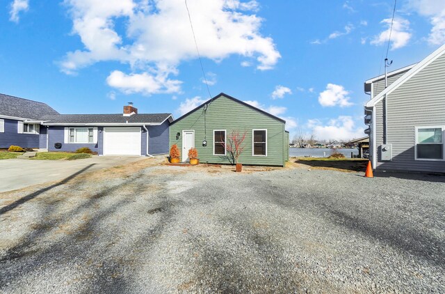 7748 Walnut St, Russells Point, OH 43348 - view of front of home with an attached garage, a water view, and driveway