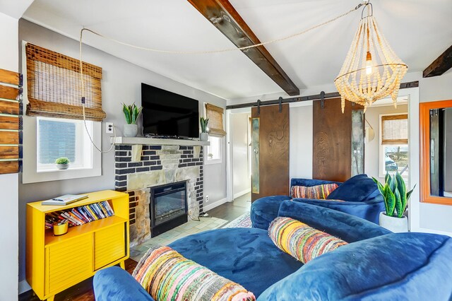 7748 Walnut St, Russells Point, OH 43348 - living room with a barn door, beam ceiling, a healthy amount of sunlight, and a fireplace with flush hearth