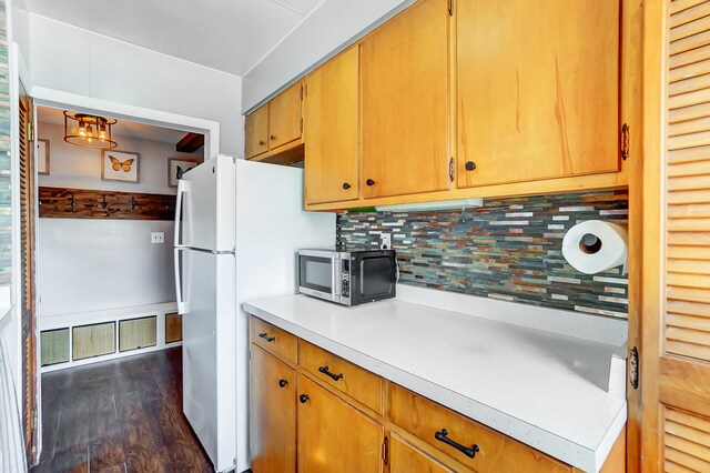 7748 Walnut St, Russells Point, OH 43348 - kitchen featuring visible vents, dark wood-type flooring, stainless steel microwave, tasteful backsplash, and light countertops