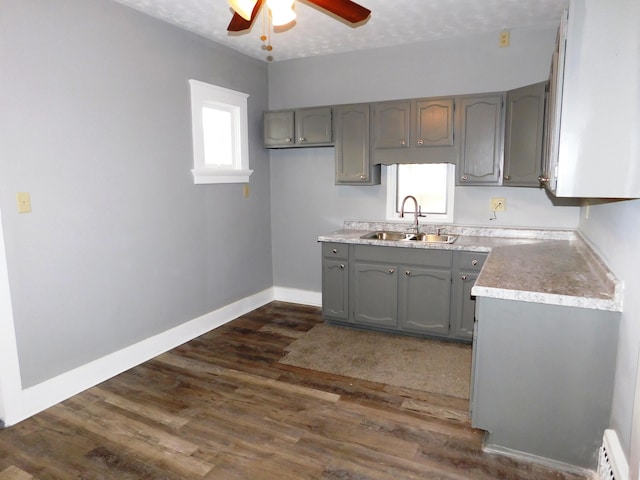 kitchen featuring gray cabinets, ceiling fan, sink, and dark hardwood / wood-style flooring