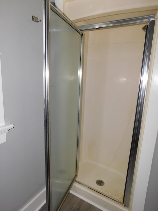 bathroom with hardwood / wood-style flooring and an enclosed shower