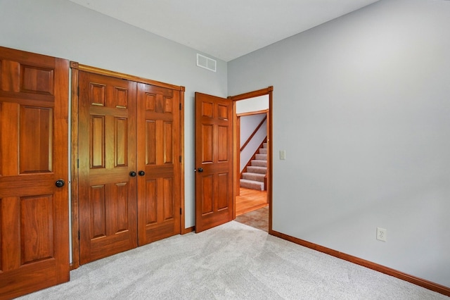 carpeted bedroom featuring a closet and baseboards