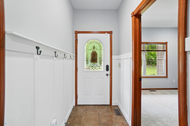 doorway with stone finish flooring, carpet, and baseboards