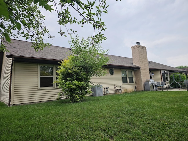 1308 Stonyridge Ave, Troy, OH 45373 - back of property featuring a yard, a patio area, a chimney, and roof with shingles