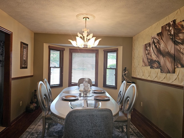 1308 Stonyridge Ave, Troy, OH 45373 - dining space featuring wood finished floors, a chandelier, and a textured ceiling