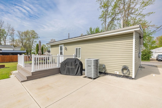 back of house featuring fence, a patio, cooling unit, and a deck