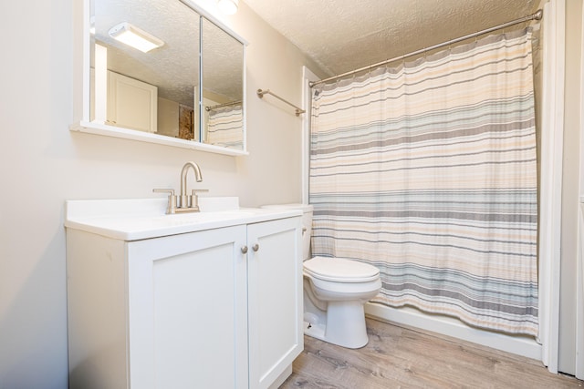 full bath featuring vanity, toilet, a textured ceiling, curtained shower, and wood finished floors