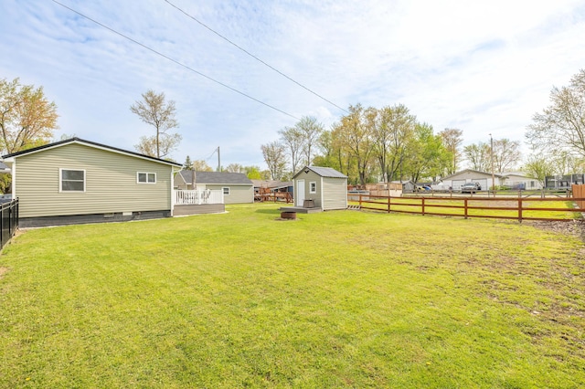view of yard featuring a storage unit, a fenced backyard, and an outdoor structure