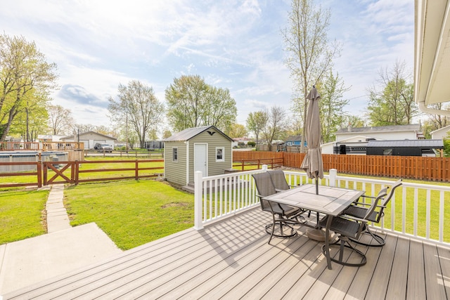 deck with an outdoor structure, outdoor dining area, a fenced backyard, a storage unit, and a lawn