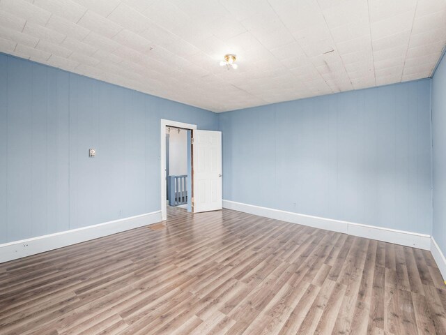 unfurnished room featuring wood finished floors and baseboards