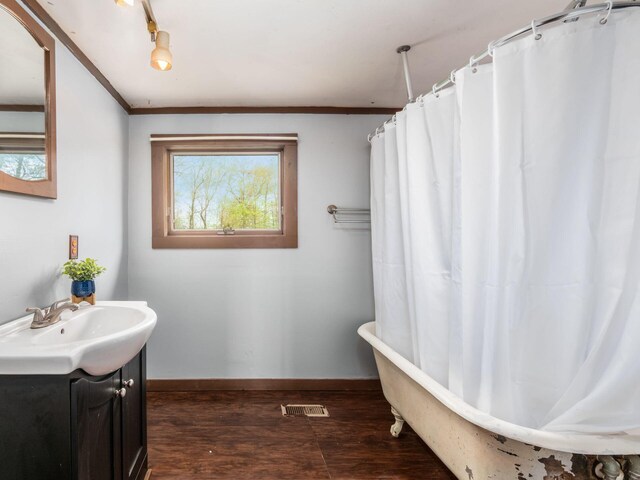 full bathroom featuring vanity, wood finished floors, a bathtub, baseboards, and a shower with curtain