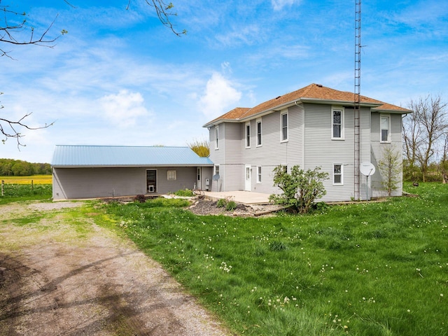 rear view of property featuring a patio and a lawn