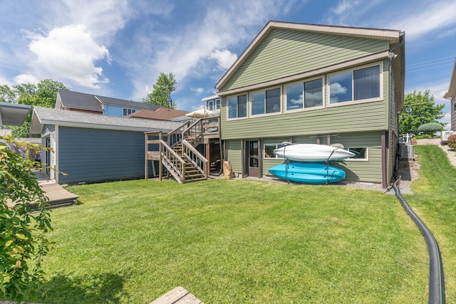 8886 State Route 368, Huntsville, OH 43324 - back of property with stairway, a deck, a lawn, and central AC