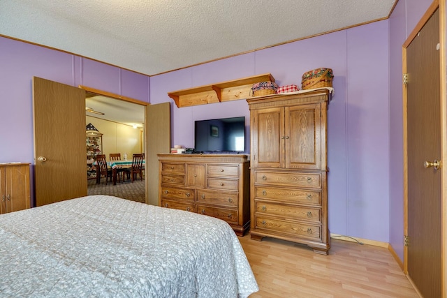 bedroom with light wood-style flooring and a textured ceiling