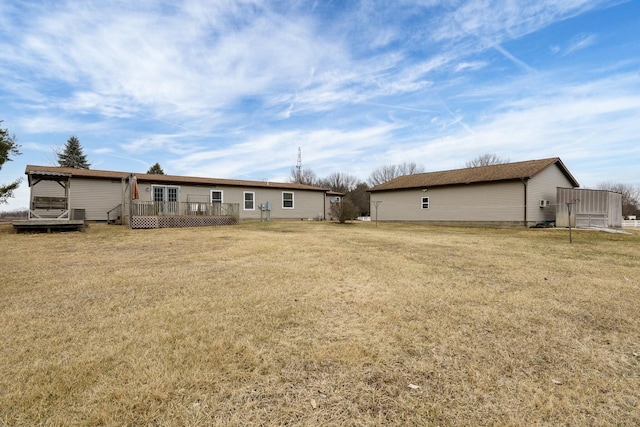 rear view of house with a yard and a deck