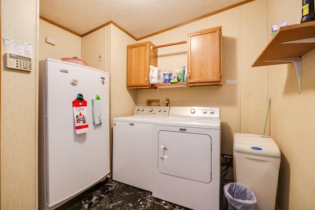 laundry room with a textured ceiling, marble finish floor, ornamental molding, cabinet space, and washing machine and clothes dryer