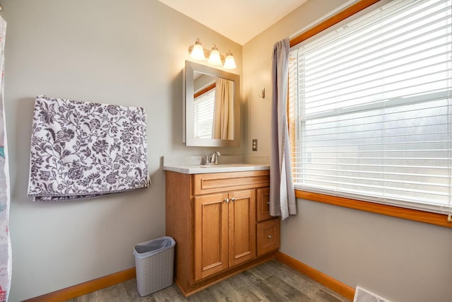 bathroom featuring visible vents, baseboards, wood finished floors, and vanity