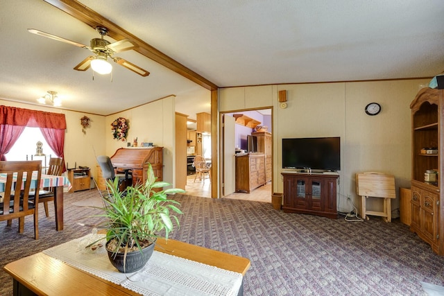 carpeted living area featuring vaulted ceiling with beams, ceiling fan, and ornamental molding