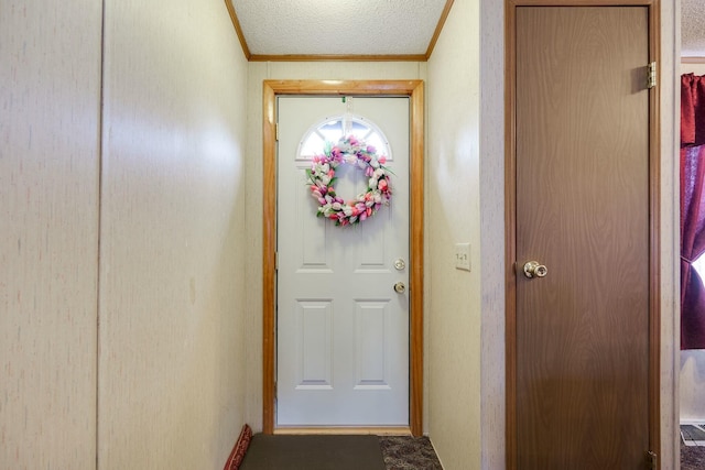 doorway to outside featuring ornamental molding and a textured ceiling