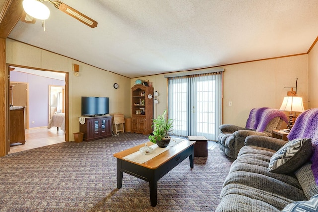 living area with lofted ceiling, carpet, ornamental molding, and a textured ceiling