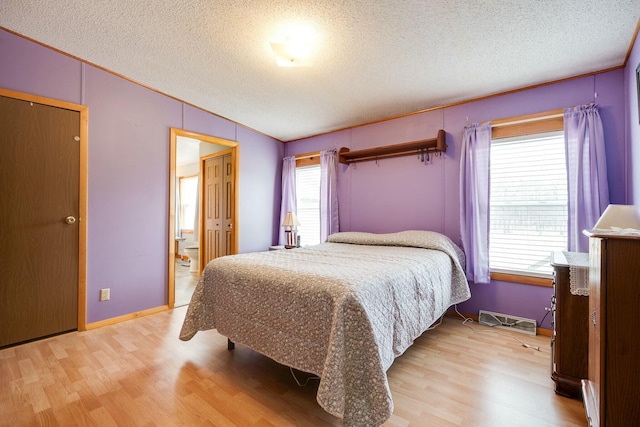 bedroom with lofted ceiling, ornamental molding, a textured ceiling, and light wood-style floors