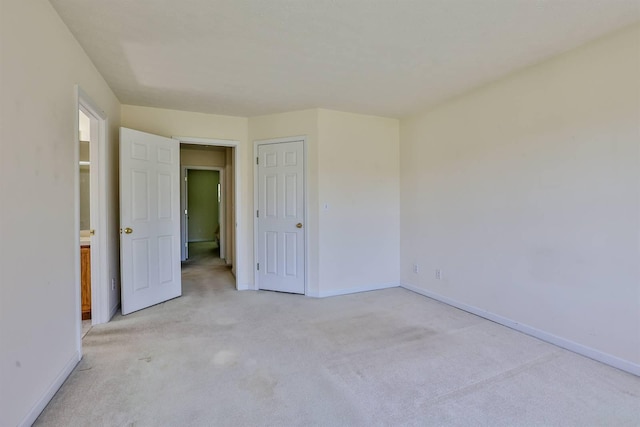 unfurnished bedroom with baseboards and light carpet