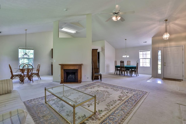 living room with high vaulted ceiling, light colored carpet, baseboards, and a fireplace