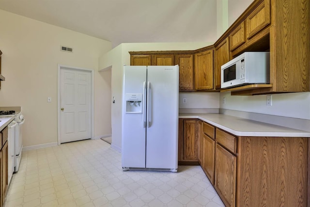 kitchen featuring white appliances, light countertops, visible vents, and light floors