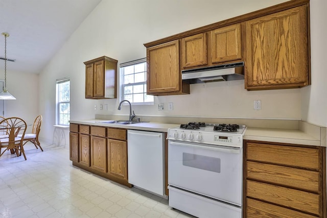 kitchen with brown cabinetry, lofted ceiling, white appliances, under cabinet range hood, and a sink