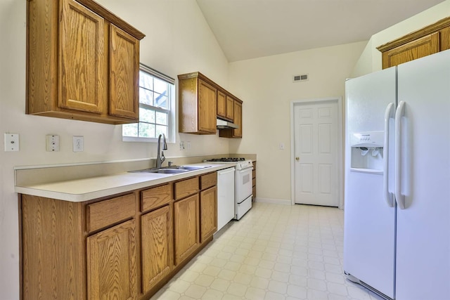 kitchen featuring brown cabinetry, visible vents, a sink, under cabinet range hood, and white appliances
