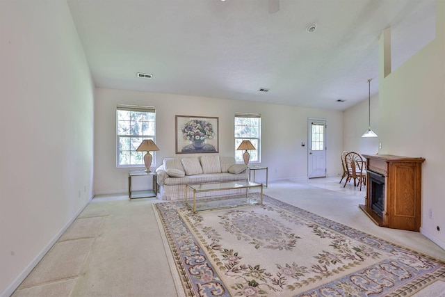 living area with baseboards, visible vents, light carpet, and a fireplace