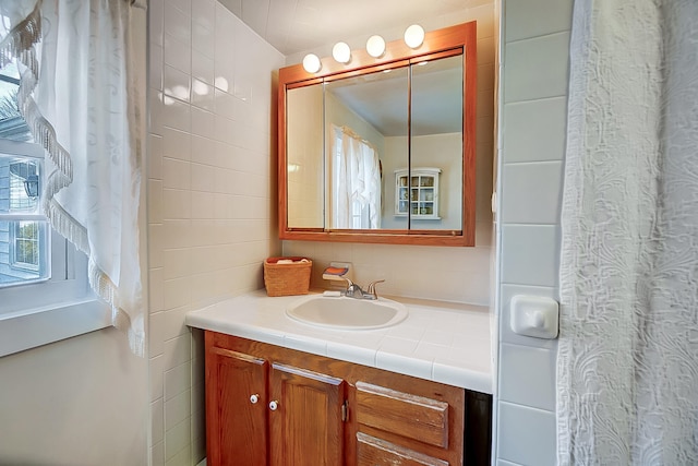 bathroom with vanity and tile walls