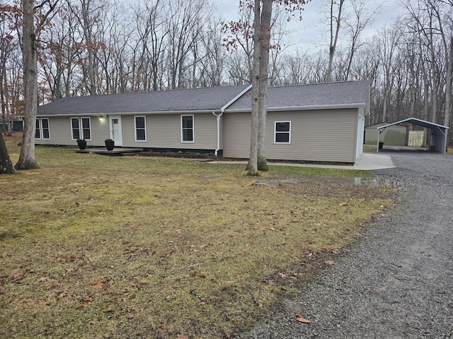 single story home with an outbuilding, a carport, and a front yard