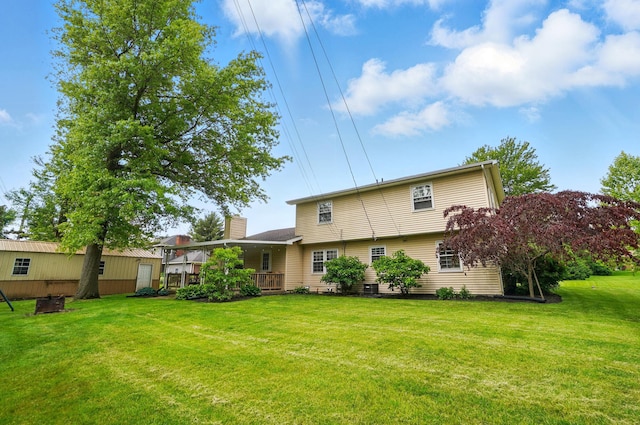2357 London Dr, Lima, OH 45805 - rear view of house with a lawn, a chimney, and a deck