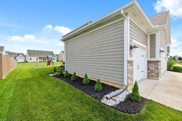 2306 Larkspur Dr, Troy, OH 45373 - view of home's exterior with a playground, an attached garage, stone siding, driveway, and a shingled roof