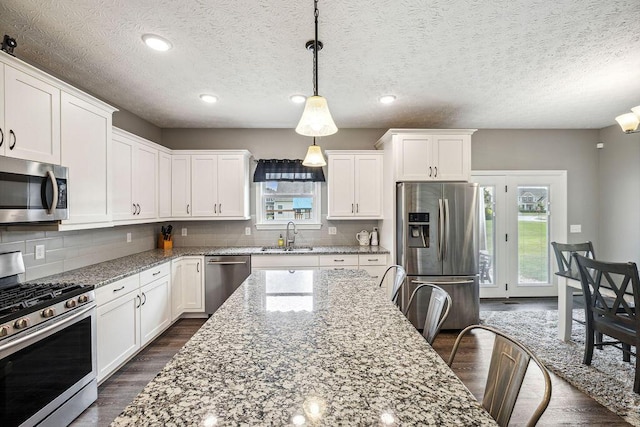 2306 Larkspur Dr, Troy, OH 45373 - kitchen with appliances with stainless steel finishes, dark wood finished floors, white cabinetry, decorative light fixtures, and recessed lighting